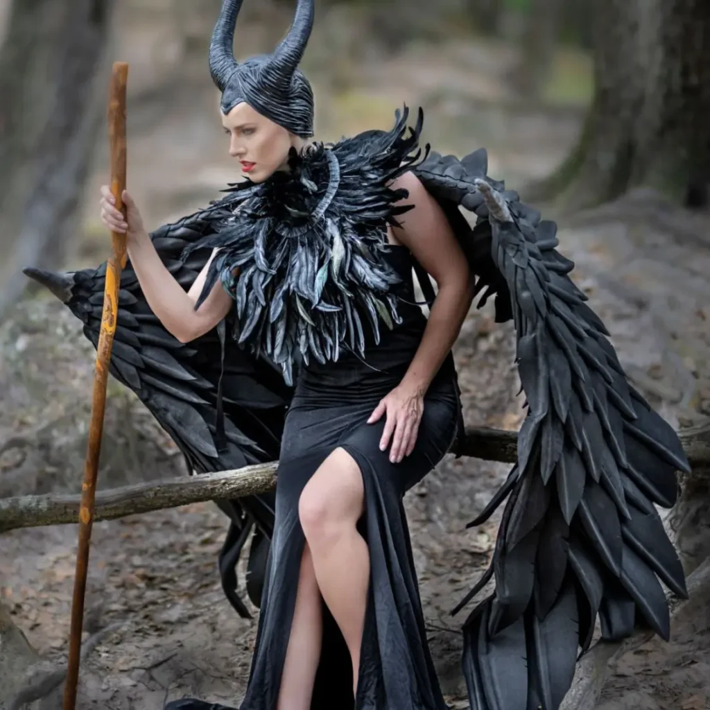 Your Retreat Host Shannon Scott dressed as Maleficent with dramatic horns, dark glam makeup, and a powerful gaze, standing in an enchanted, moody setting for Halloween.