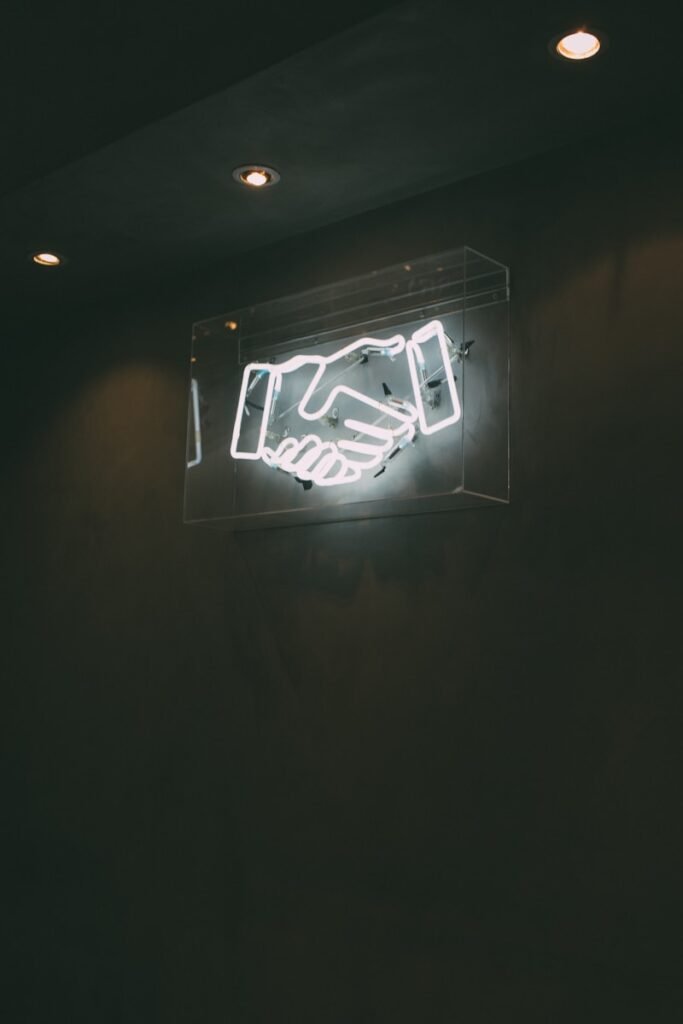 Sign with two hands shaking, symbolizing collaboration and connection within the acting community.