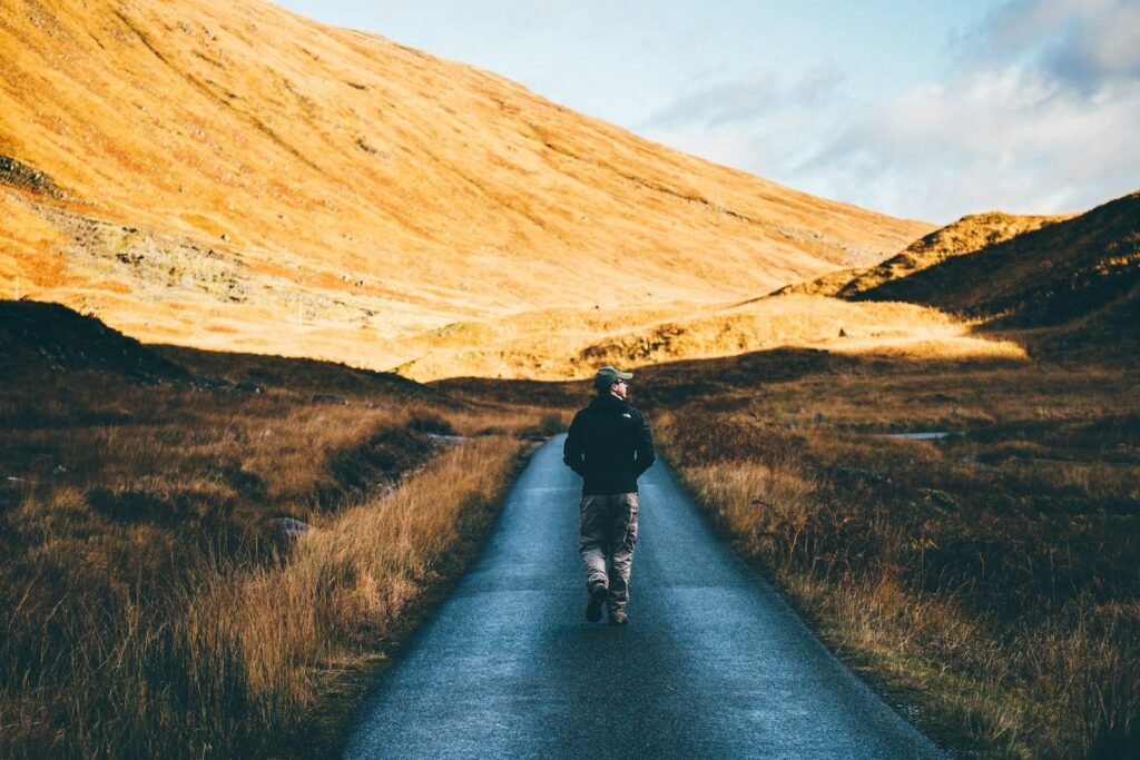 Performer walking alone on a quiet road, reflecting and reconnecting with themselves.