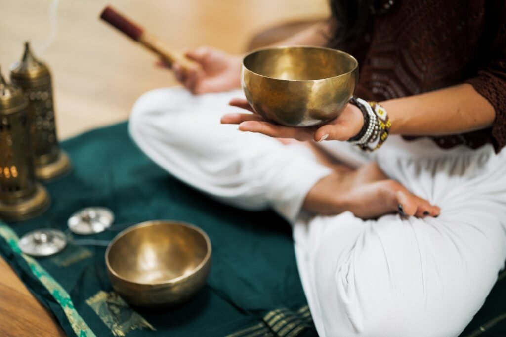 A person seated in peaceful reflection, holding a sound bowl during an immersive retreat experience focused on mindfulness and inner renewal.