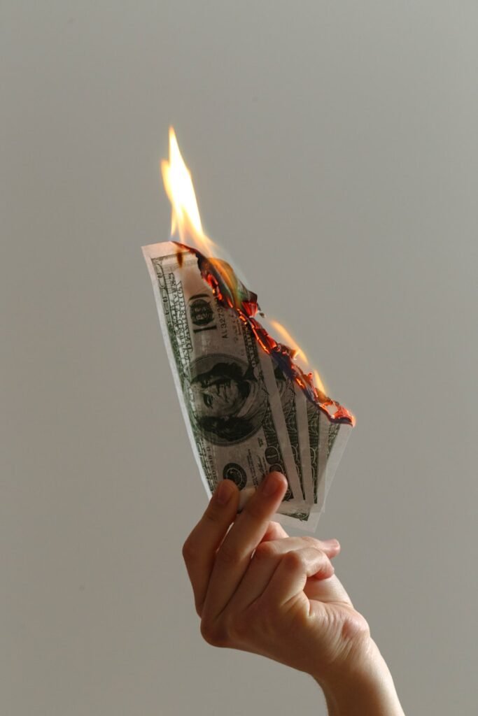 Burning money representing the high emotional cost of creative burnout and the need for an emotional reset for performers.
